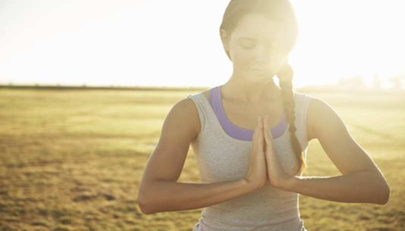 Woman meditating on a beach