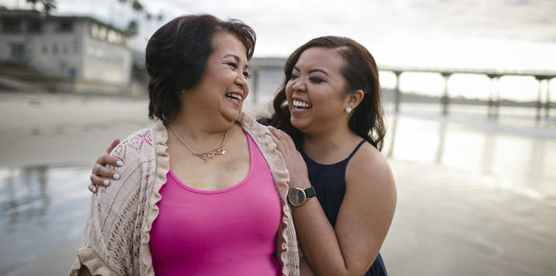 Mother and daughter smiling at the beach