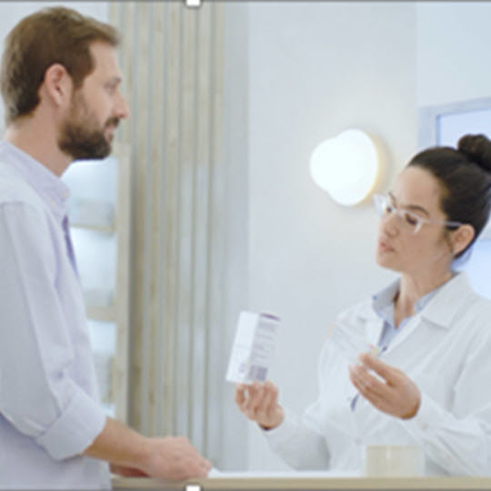 Man checking medicine with pharmacist
