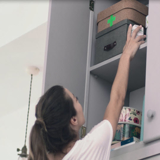 Woman storing medicine in safe place