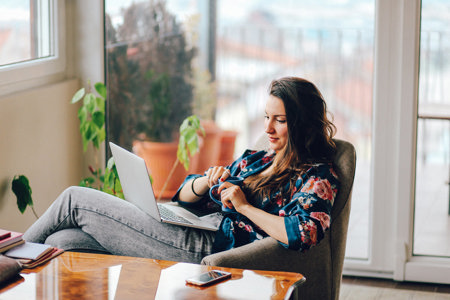 Girl drinking coffee and looking at a laptop