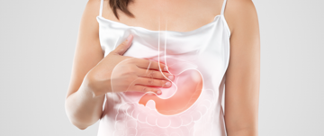 A woman holding her stomach with her hand, appearing to be in discomfort.