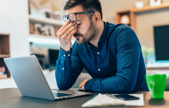 Stressed man holding his head