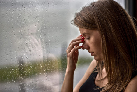 woman with migraine triggered-by-barometric pressure shift due to rain Woman with migraine triggered by barometric pressure shift due to rain