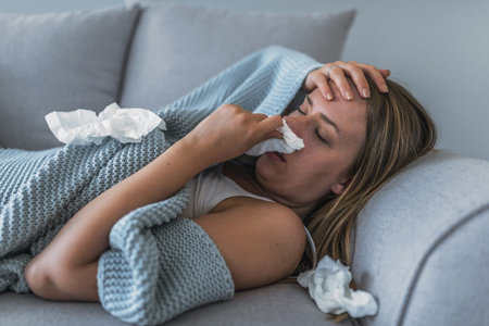 woman with stuffed nose laying on sofa Woman with stuffed nose laying on sofa
