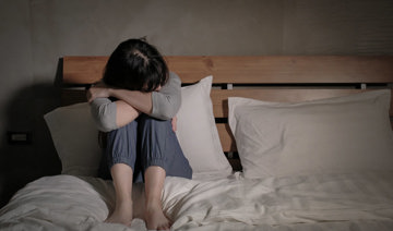 An anxious woman sitting on a bed