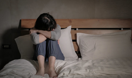 An anxious woman sitting on a bed
