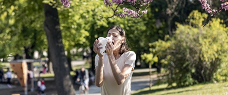 Woman Blowing Her Nose With Handkerchief In Public Park