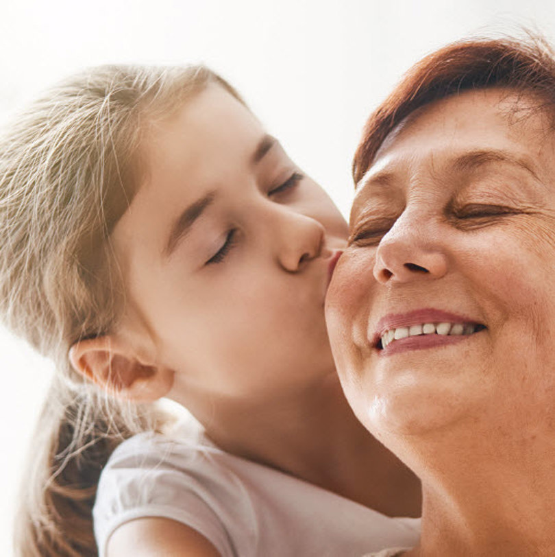Girl kissing her mother on the cheek