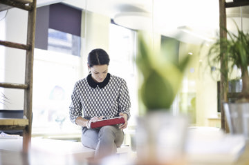 A woman sitting in a modern office, focused on her work