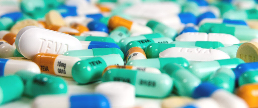 A series of generic Teva medication pills spilled on the table