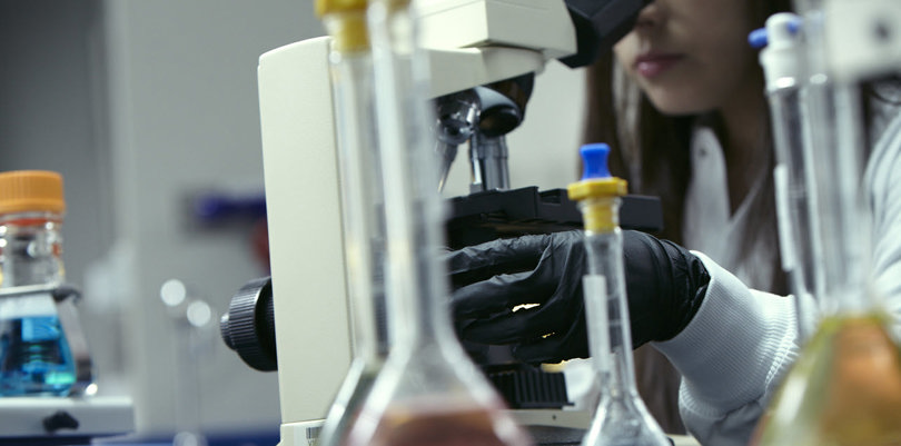 Woman watching on microscope