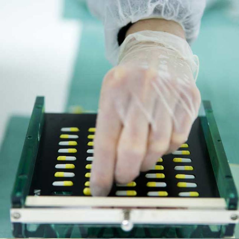 Hand sorting pills in a tray