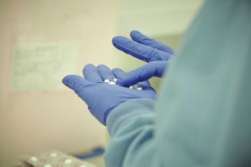 Scientist counting pills on a hand