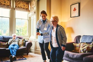 Nurse helping woman to walk