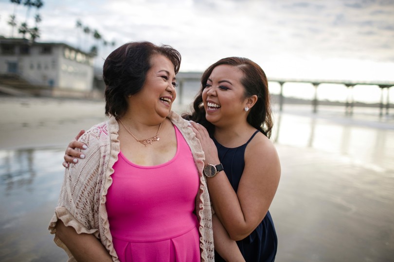 woman and daughter laughing at the beach