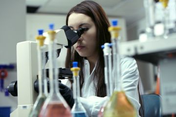 Woman looking through a microscope