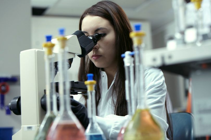 Woman looking through a microscope