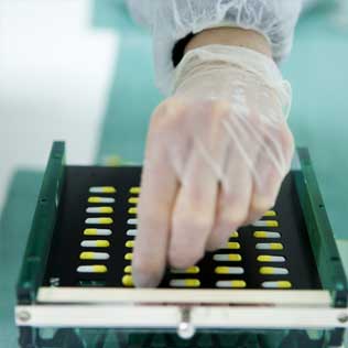 A gloved hand taking a pill