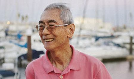A man smiling at a harbor