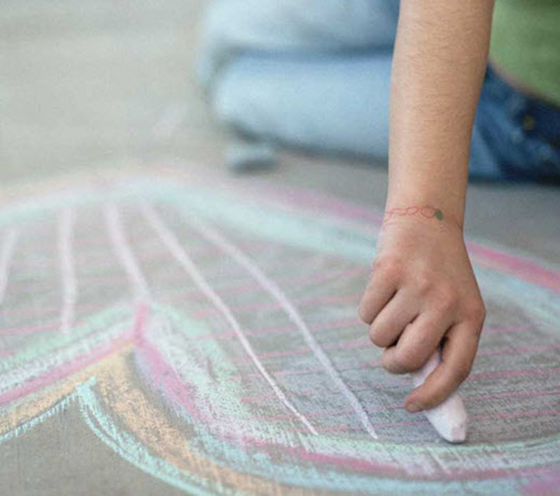 Hand drawing a heart on the floor with chalk