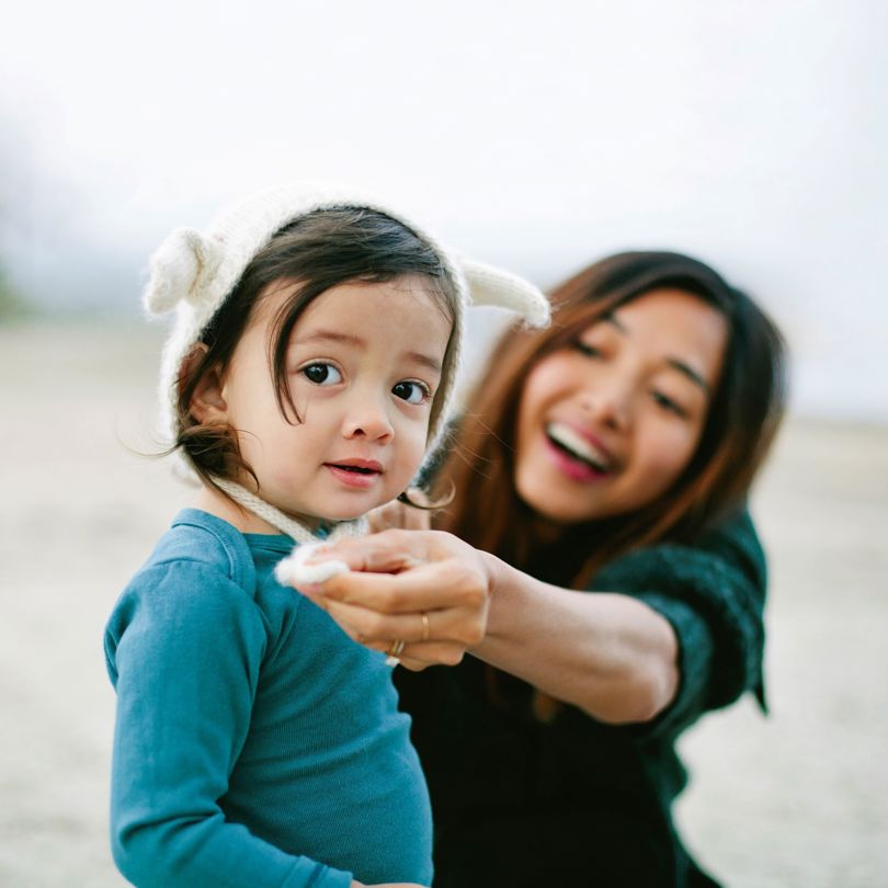 Woman-tying-hat-for-little-girl